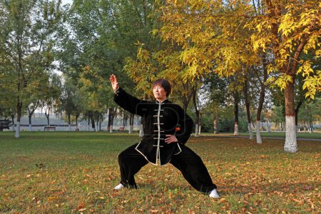 Photo for LUANNAN COUNTY, Hebei Province, China - October 18, 2020: People practice Taijiquan in the woods - Royalty Free Image