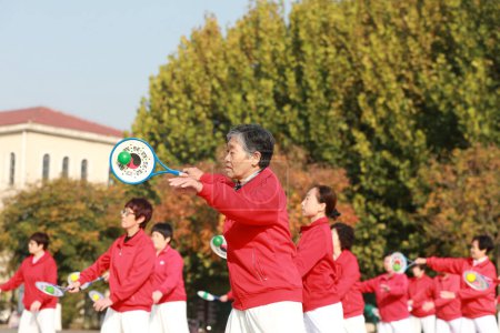 Foto de LUANNAN COUNTY, provincia de Hebei, China - 18 de octubre de 2020: Las señoras están practicando softbol Tai Chi en la plaza - Imagen libre de derechos