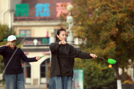 Foto de LUANNAN COUNTY, China - 25 de octubre de 2020: Diabolo performance in the park square, LUANNAN COUNTY, Hebei Province, China - Imagen libre de derechos