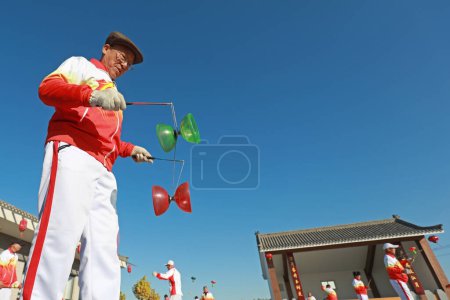 Photo for FENGNAN COUNTY, Hebei Province, China - November 3, 2020: People are practicing diabolo in the square, North China - Royalty Free Image