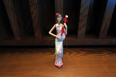 Photo for A figure dressed in cheongsam and embracing musical instruments - Royalty Free Image