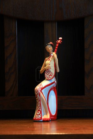 Téléchargez les photos : Une figure vêtue de cheongsam et embrassant des instruments de musique - en image libre de droit
