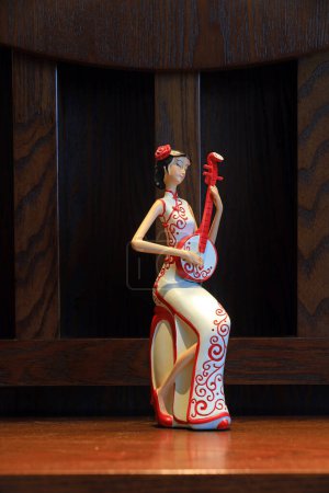 Photo for A figure dressed in cheongsam and embracing musical instruments - Royalty Free Image