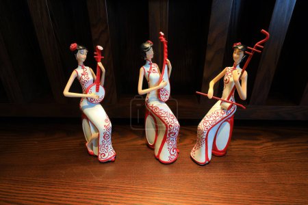 A figure dressed in cheongsam and embracing musical instruments