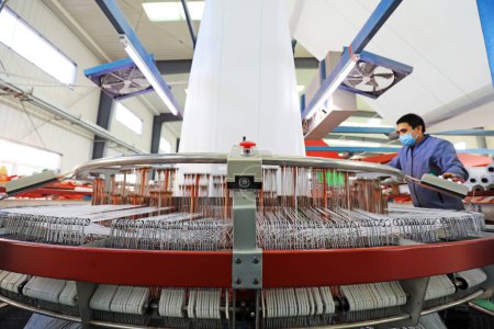 Foto de LUANNAN COUNTY, China - 8 de diciembre de 2020: los trabajadores están ocupados en una línea de productos de embalaje en una fábrica, LUANNAN COUNTY, Hebei Province, China - Imagen libre de derechos