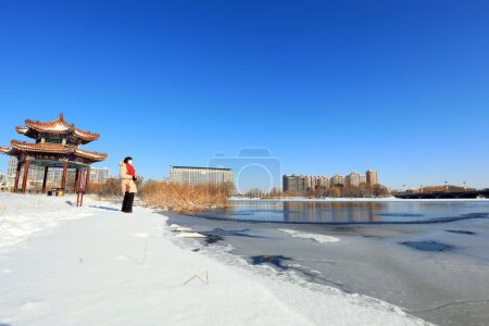 Téléchargez les photos : COMTÉ DE LUANNAN, Chine - 13 décembre 2020 : une femme joue dans la neige dans un parc, COMTÉ DE LUANNAN, province du Hebei, Chine - en image libre de droit