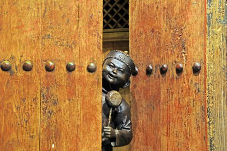 Téléchargez les photos : Tangshan City, Chine - 22 décembre 2020 : Des sculptures chinoises anciennes en bronze pour enfants dans une fissure à la porte se trouvent dans un hall d'exposition, ville de Tangshan, province du Hebei, Chine - en image libre de droit