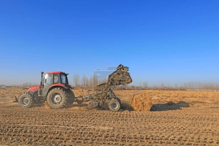Téléchargez les photos : COMTÉ DE LUANNAN, Chine - 24 décembre 2020 : les agriculteurs utilisent des machines agricoles pour comprimer la paille de riz et les empaqueter sur une ferme, COMTÉ DE LUANNAN, province du Hebei, Chine - en image libre de droit