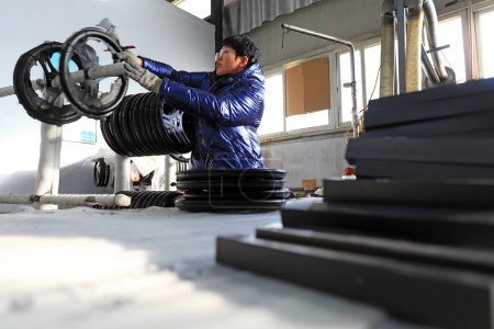 Foto de CONDADO DE LUANNAN, China - 7 de enero de 2021: los trabajadores trabajan en un taller en una línea de producción en el condado de LUANNAN, provincia de Hebei, China - Imagen libre de derechos