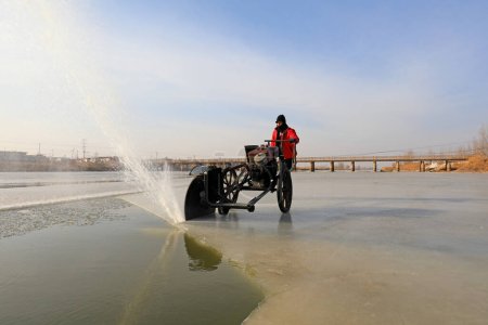 Téléchargez les photos : COMTÉ DE LUANNAN, province du Hebei, Chine - 22 janvier 2021 : Les agriculteurs utilisent des scies électriques pour couper la glace de rivière dans la nature - en image libre de droit