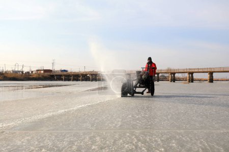 Téléchargez les photos : COMTÉ DE LUANNAN, province du Hebei, Chine - 22 janvier 2021 : Les agriculteurs utilisent des scies électriques pour couper la glace de rivière dans la nature - en image libre de droit