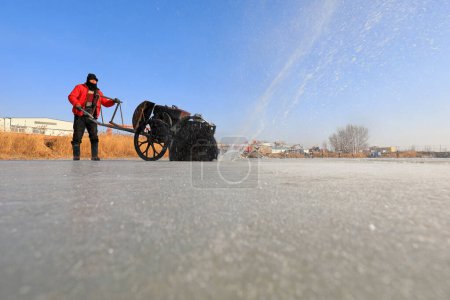 Photo for LUANNAN COUNTY, Hebei Province, China - January 22, 2021: Farmers use electric saws to cut river ice in the wild - Royalty Free Image