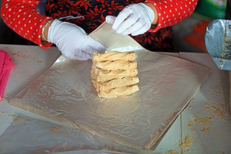 Foto de Los hogares de procesamiento están empacando caramelos crujientes de maní en un taller familiar. - Imagen libre de derechos
