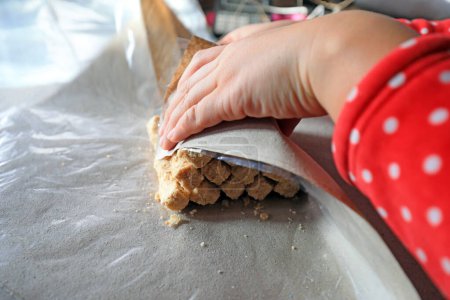 Téléchargez les photos : Les ménages de transformation emballent des bonbons croquants aux arachides dans un atelier familial. - en image libre de droit