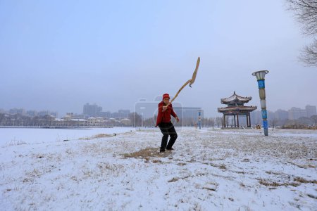 Photo for LUANNAN COUNTY - February 2, 2020: A martial arts enthusiast practices martial arts in the snow, LUANNAN COUNTY, Hebei Province, China - Royalty Free Image