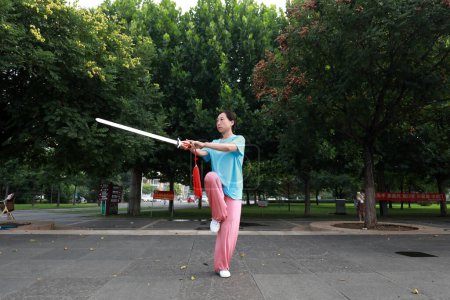 Photo for LUANNAN COUNTY, Hebei Province, China - August 2, 2020: People are practicing Taiji sword in the park - Royalty Free Image