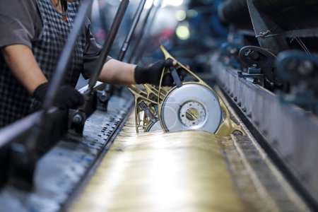 The workers are working on a mechanical fishing net in a net factory