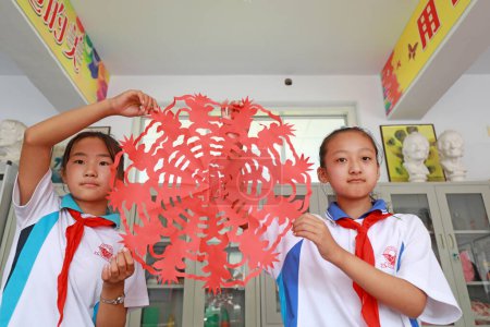 Téléchargez les photos : COMTÉ DE LUANNAN, Province du Hebei, Chine - 27 septembre 2020 : Des élèves du primaire montrent des travaux de découpe de papier en classe - en image libre de droit