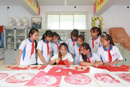 Téléchargez les photos : COMTÉ DE LUANNAN, Province du Hebei, Chine - 27 septembre 2020 : Sous la direction des enseignants, les élèves du primaire apprennent l'art de couper le papier en classe - en image libre de droit