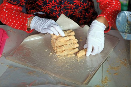Los hogares de procesamiento están empacando caramelos crujientes de maní en un taller familiar.