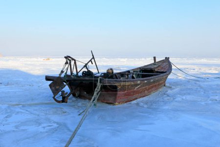 Wooden boats in ice and snow, closeup of photo