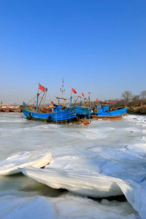 Wooden fishing boats in the ice
