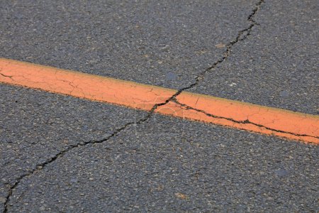 Foto de Líneas amarillas y grietas en carreteras de asfalto, primer plano de la foto - Imagen libre de derechos