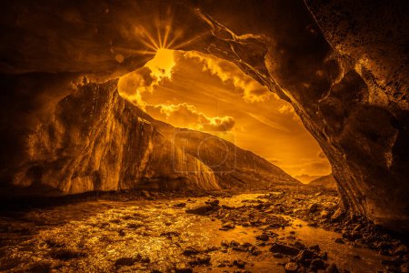 Foto de Efecto naranja de fantasía de la corriente glacial que sale de una cueva tallada en el glaciar Vallelunga. El glaciar está en rápida retirada causada por el calentamiento global, Alto Adigio, Italia. Imagen abstracta - Imagen libre de derechos