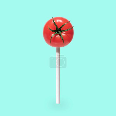 Téléchargez les photos : Des bonbons à la tomate sur un bâton. Minimal concept pop art de manger sainement et des bonbons. Photo de haute qualité - en image libre de droit