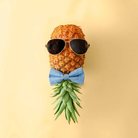 Téléchargez les photos : Ananas ludique dans les lunettes de soleil et noeud papillon. Concept minimal de fruits tropicaux de l'été et de la mode. Photo de haute qualité - en image libre de droit