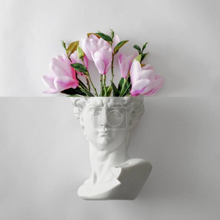 Téléchargez les photos : Buste de statue Davids de Michel-Ange et un bouquet de fleurs comme un cerveau. Concept ludique minimal de cadeau de printemps et de créativité et d'art. Photo de haute qualité - en image libre de droit