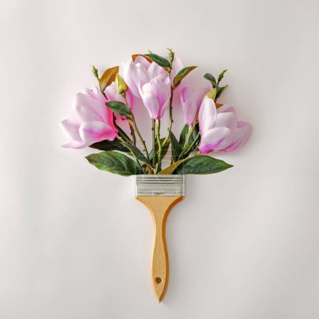 Téléchargez les photos : Bouquet créatif minimal avec des fleurs et des pinceaux pour la peinture. Concept ludique minimal de printemps et de créativité. Photo de haute qualité - en image libre de droit