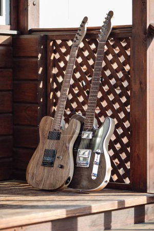 Foto de Las guitarras eléctricas están apoyadas en una escalera de madera en la terraza - Imagen libre de derechos