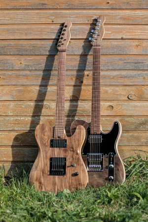 Foto de Las guitarras eléctricas se apoyan en una pared de madera exterior - Imagen libre de derechos