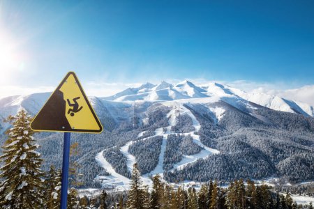 Foto de Señal de advertencia amarilla en una estación de esquí, pistas de esquí en el fondo - Imagen libre de derechos