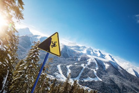 Téléchargez les photos : Panneau d'avertissement jaune dans une station de ski, pistes de ski en arrière-plan - en image libre de droit