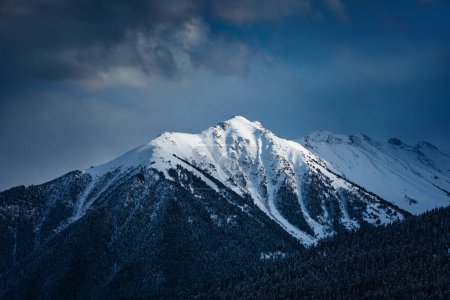 Foto de Dramática vista del pico de la montaña. Los últimos rayos del sol poniente iluminando la cumbre - Imagen libre de derechos