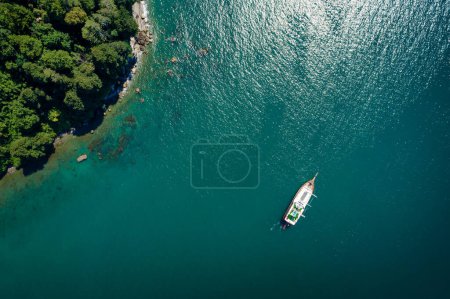 Téléchargez les photos : Vue de dessus d'un voilier ancré au large d'une côte rocheuse - en image libre de droit