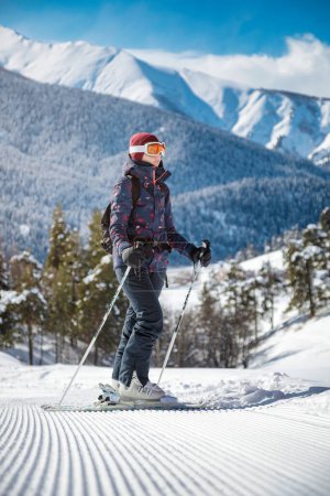 Foto de Esquiadora amateur disfrutando de la vista de las montañas en la pista de terciopelo en un día soleado en una estación de esquí. - Imagen libre de derechos
