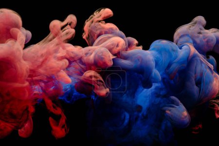Téléchargez les photos : Collision of flow of red and blue ink on a black background. Abstract concept photo - en image libre de droit