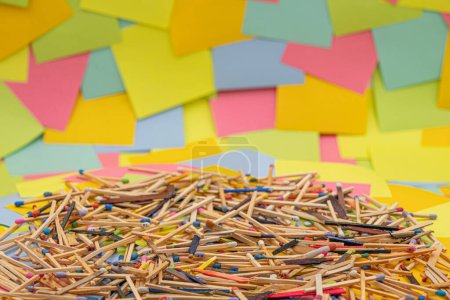 Foto de Matchsticks of various shapes and colors with multicolored paper sticky notes on background - Imagen libre de derechos