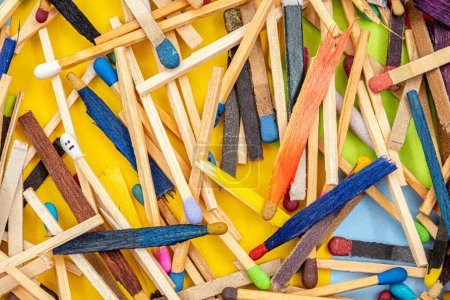 Foto de Matchsticks of various shapes and colors with multicolored paper sticky notes on background - Imagen libre de derechos