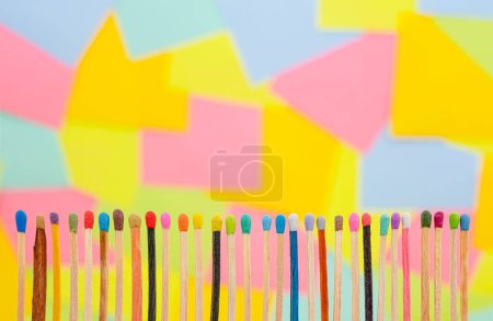 Téléchargez les photos : Allumettes de différentes formes et couleurs avec des notes collantes en papier multicolore sur fond - en image libre de droit