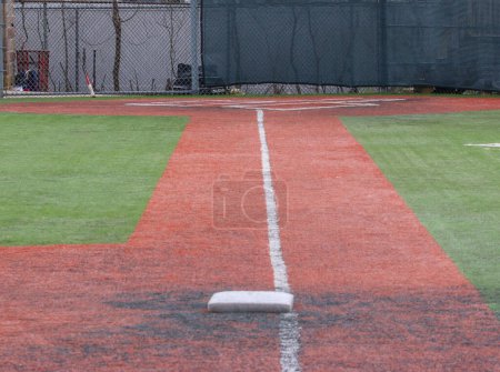 Téléchargez les photos : Looking down the white foul line from third base to the batter box of a turf baseball field - en image libre de droit
