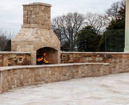 Téléchargez les photos : Pavage patio en pierre avec une cheminée en pierre brûlante et aucun peuple. - en image libre de droit