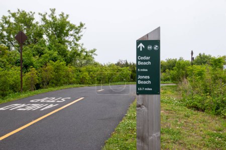Photo for Sign post showing the milage on a bike path to Jones Beach from Captree State Park on the south shore of long island new york. - Royalty Free Image