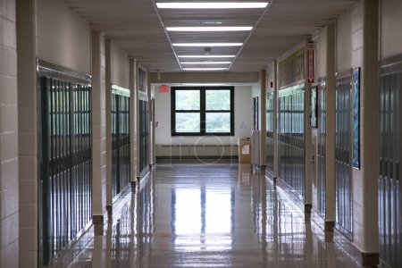 Foto de Un pasillo de secundaria americano vacío con taquillas en ambos lados y una ventana al sur al final. - Imagen libre de derechos