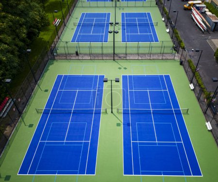 Téléchargez les photos : En regardant six courts de tennis qui sont également doublés pour pickleball avec une surface bleue et verte et des lumières pour jouer la nuit. - en image libre de droit