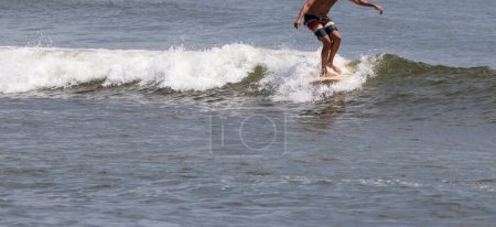 Photo for Front view of a surfer riding a wave at Gilgo Beach in July of 2023. - Royalty Free Image