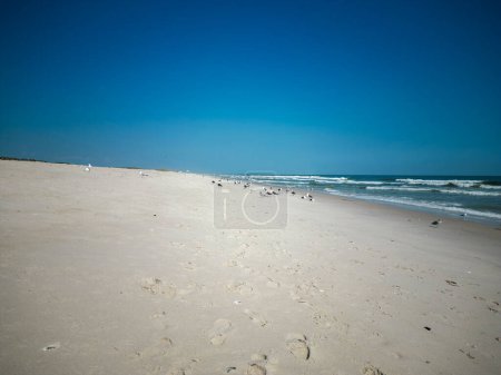 Photo for Looking down at footprints in the sand at Gilgo Beach Long Island with a dark blue sky above. - Royalty Free Image